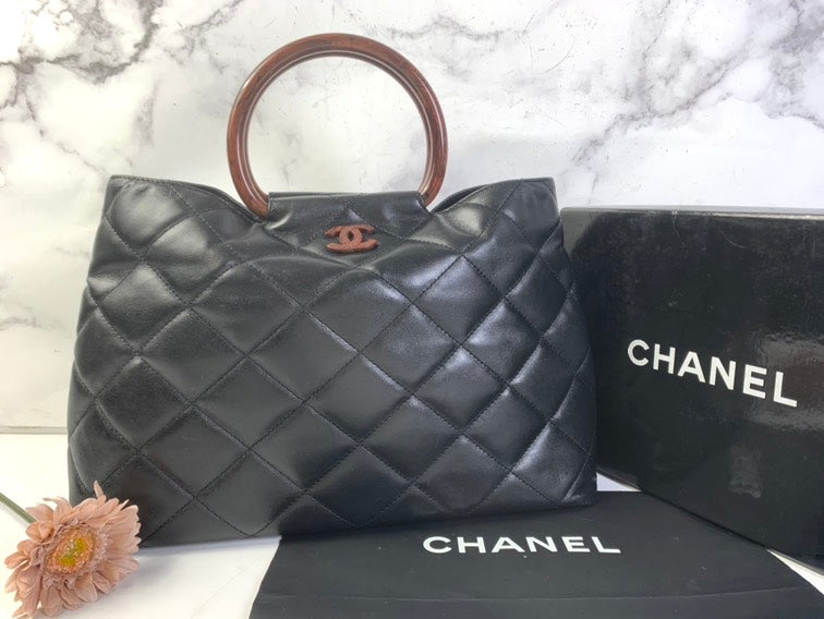 Bolso de mano de cuero acolchado negro de Chanel con asa marrón grande